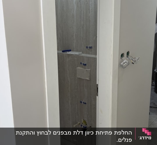 דלת לבנה פתוחה עם משקוף לבן